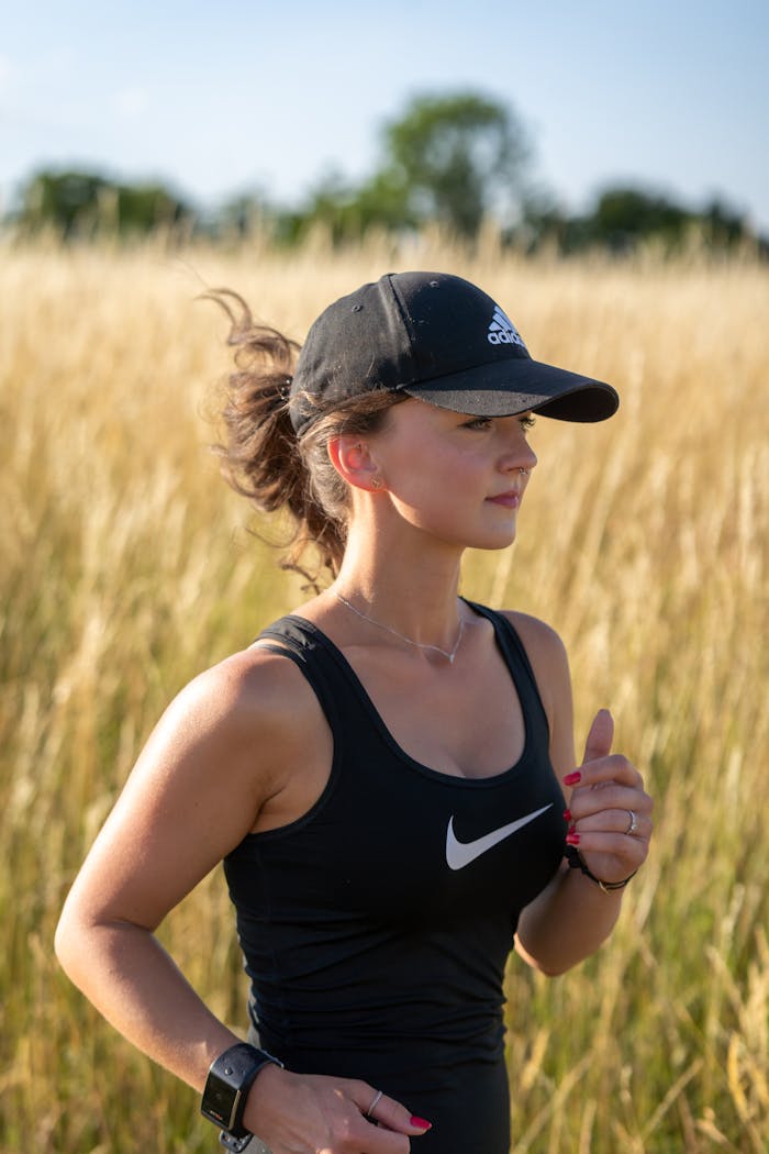 Athletic woman jogging through a golden wheat field on a sunny day.